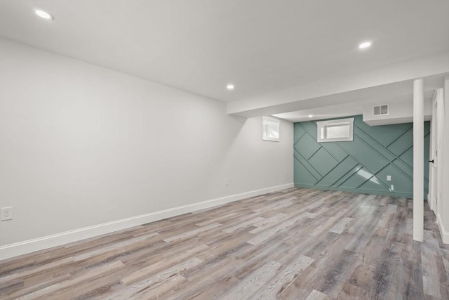below grade area with recessed lighting, light wood-style flooring, visible vents, and baseboards