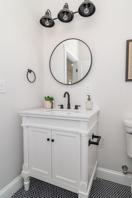 bathroom featuring baseboards, toilet, vanity, and tile patterned floors