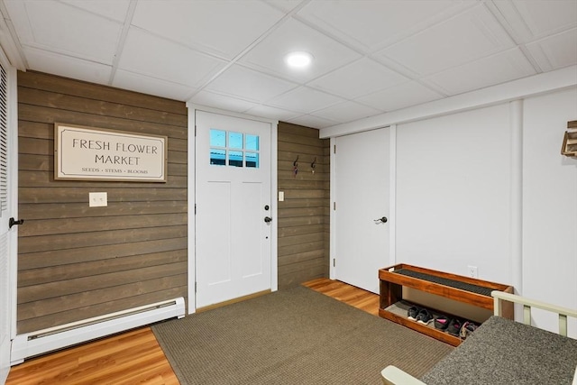 entrance foyer featuring a baseboard heating unit, wood walls, wood finished floors, and recessed lighting