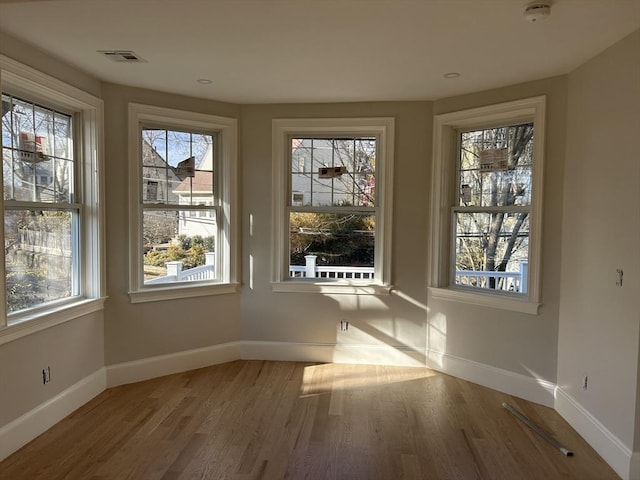 interior space featuring visible vents, baseboards, and wood finished floors