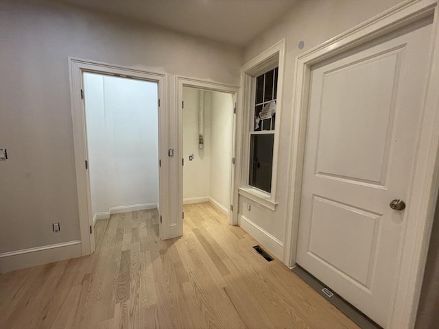 doorway featuring light wood-type flooring, baseboards, and visible vents