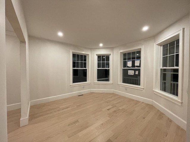 spare room featuring recessed lighting, baseboards, and light wood finished floors