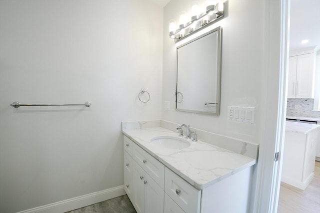 bathroom with baseboards, tasteful backsplash, and vanity