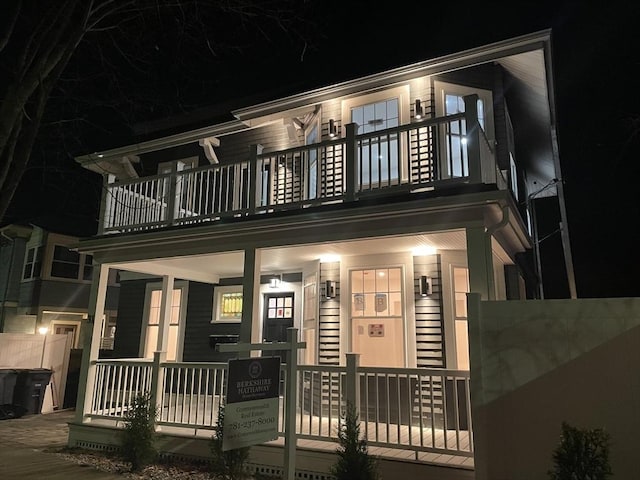 view of front of home featuring fence and a balcony