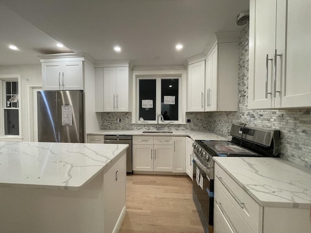 kitchen with light wood-type flooring, a sink, white cabinetry, recessed lighting, and stainless steel appliances