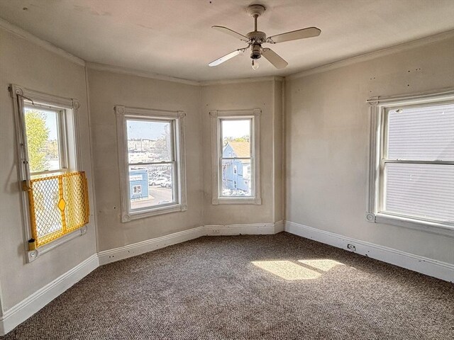 carpeted empty room with ornamental molding, plenty of natural light, baseboards, and ceiling fan