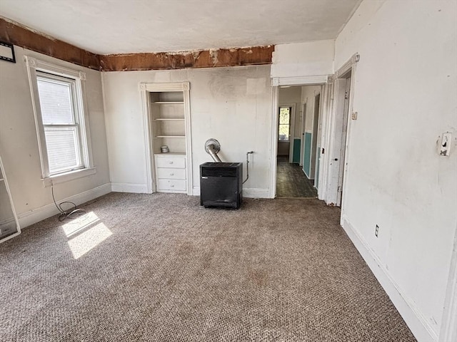 spare room with carpet flooring, plenty of natural light, baseboards, and built in features