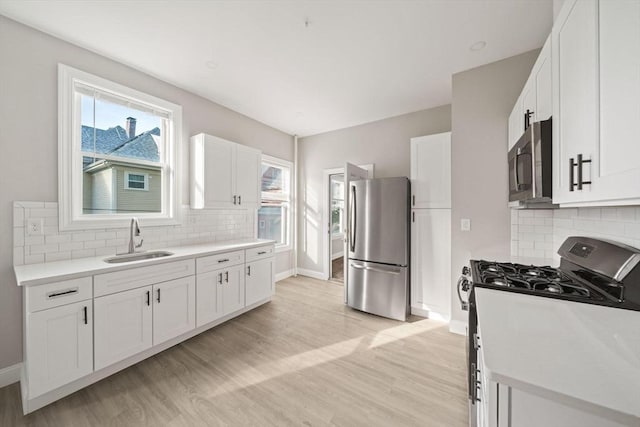 17 Magnolia Sq, Boston, MA 02125 - kitchen featuring appliances with stainless steel finishes, a sink, tasteful backsplash, and white cabinets
