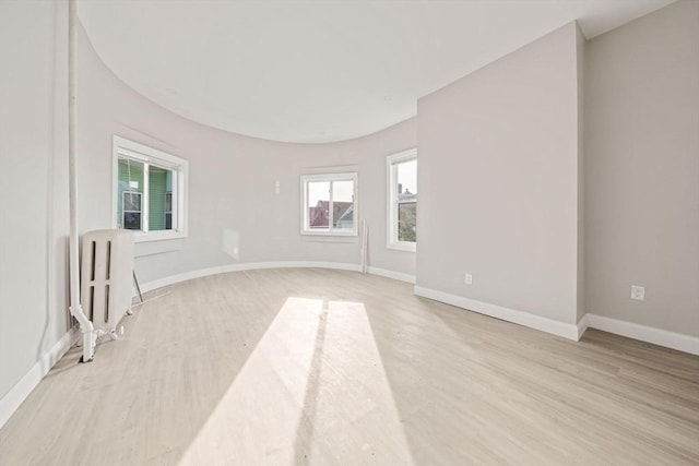 17 Magnolia Sq, Boston, MA 02125 - empty room featuring radiator heating unit, light wood finished floors, and baseboards