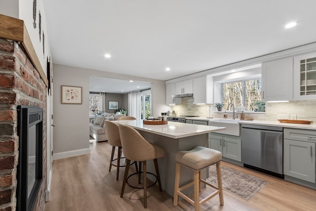 kitchen featuring decorative backsplash, a breakfast bar, stainless steel appliances, sink, and light hardwood / wood-style flooring