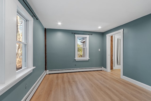 spare room with light hardwood / wood-style flooring and a baseboard heating unit