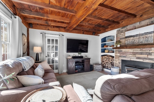 living room featuring beam ceiling, a stone fireplace, hardwood / wood-style floors, and wooden ceiling