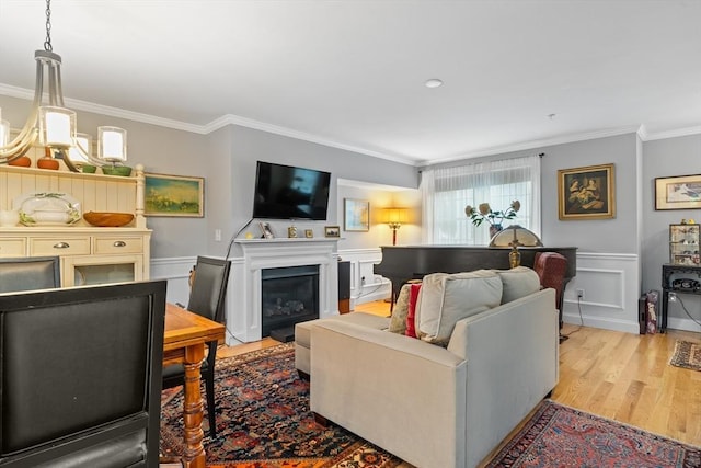 2 Heron Way Unit B, Salisbury, MA 01952 - living area with crown molding, light wood-style flooring, a chandelier, and a glass covered fireplace