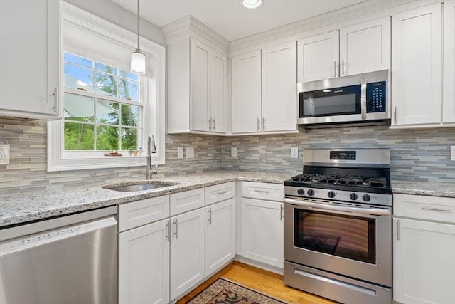 2 Heron Way Unit B, Salisbury, MA 01952 - kitchen featuring appliances with stainless steel finishes, white cabinetry, decorative backsplash, and pendant lighting