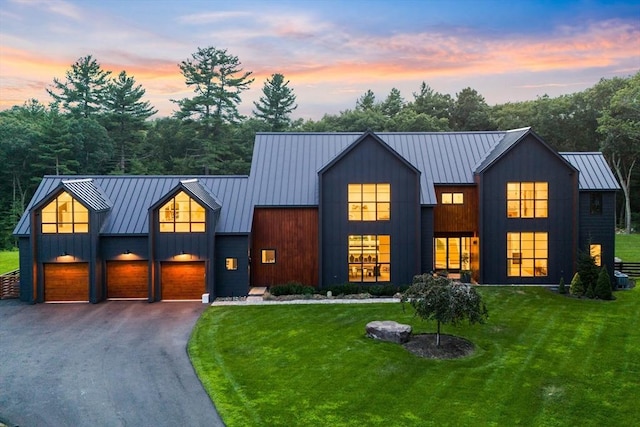 modern farmhouse with metal roof, a front lawn, a standing seam roof, and board and batten siding