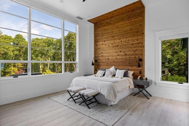 bedroom with multiple windows and wood finished floors
