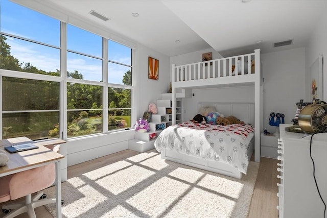 bedroom with visible vents and wood finished floors