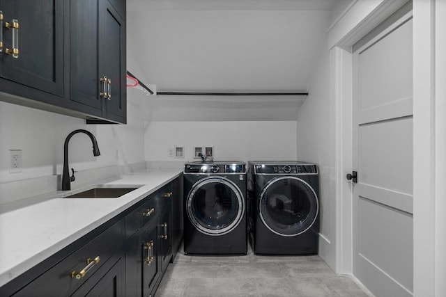 clothes washing area with cabinet space, a sink, and washer and clothes dryer