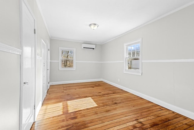 unfurnished bedroom with multiple windows, crown molding, a wall mounted AC, and light wood-type flooring