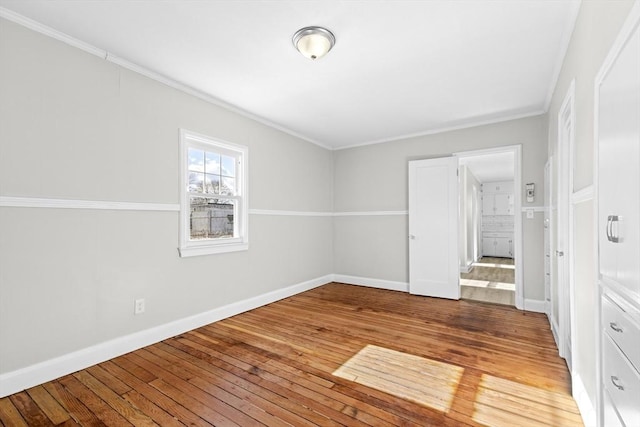 unfurnished room featuring hardwood / wood-style flooring and crown molding