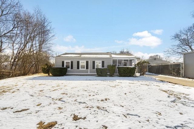 snow covered property featuring a sunroom