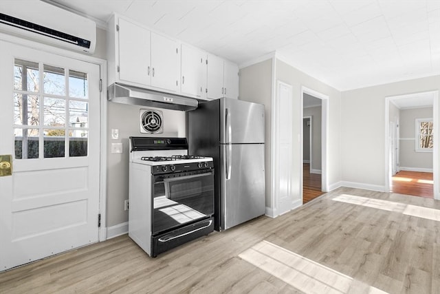 kitchen with white cabinetry, a wall mounted AC, stainless steel fridge, range with gas stovetop, and light hardwood / wood-style floors