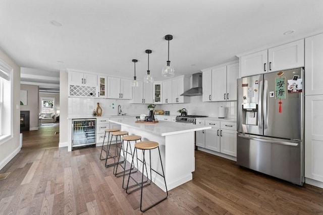 kitchen featuring stainless steel fridge with ice dispenser, white cabinetry, beverage cooler, and wall chimney exhaust hood