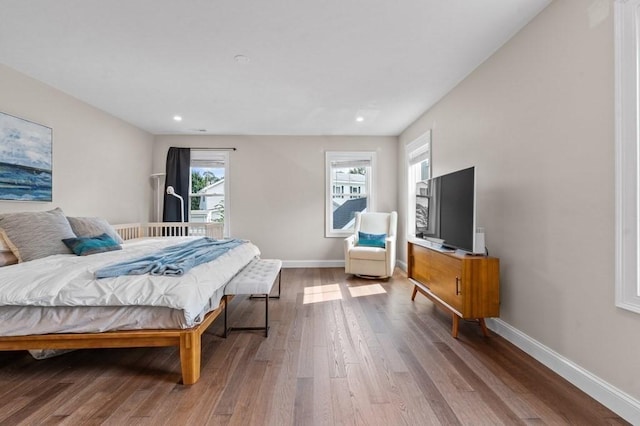 bedroom with wood-type flooring and multiple windows