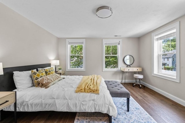 bedroom with wood-type flooring and multiple windows