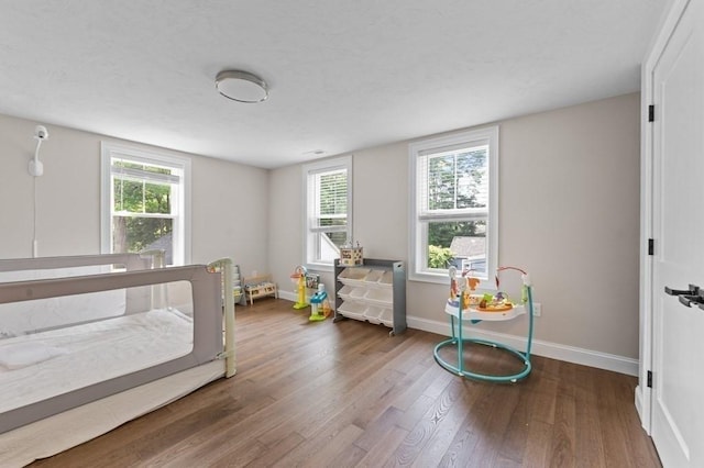 bedroom featuring hardwood / wood-style floors and multiple windows