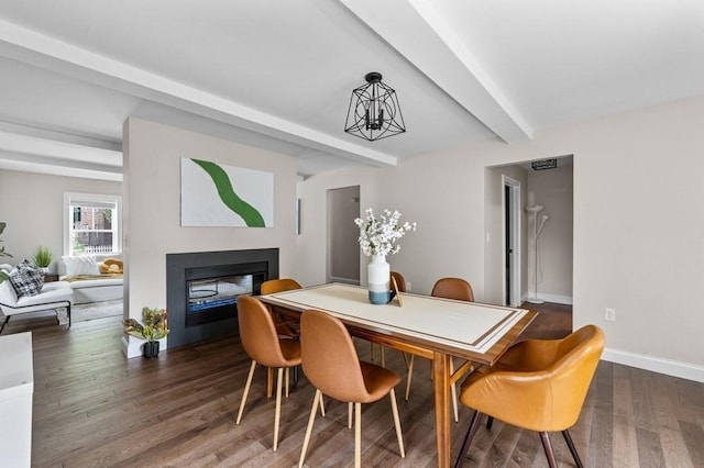 dining space with beam ceiling, dark hardwood / wood-style flooring, and a chandelier