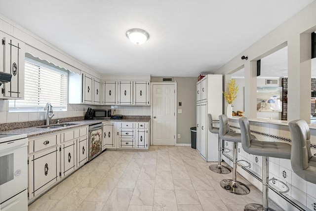 kitchen with white cabinetry, sink, tasteful backsplash, and stainless steel appliances