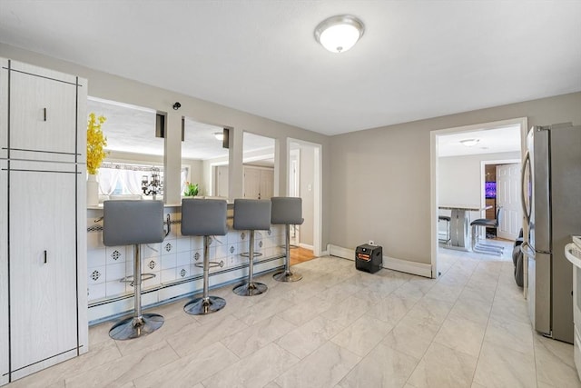 interior space with stainless steel refrigerator and a baseboard radiator