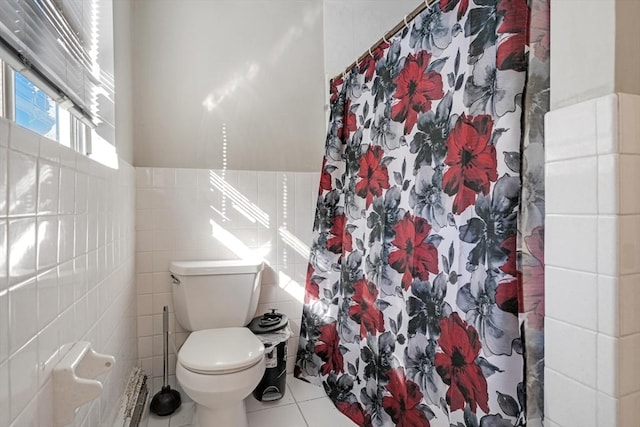 bathroom with tile walls, curtained shower, tile patterned floors, and toilet