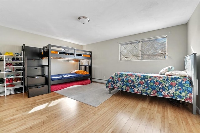 bedroom with hardwood / wood-style flooring and baseboard heating