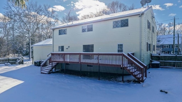 snow covered property featuring cooling unit and a deck