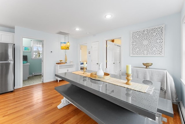 dining area featuring baseboard heating and light hardwood / wood-style flooring