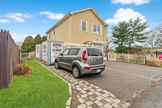 view of side of property with a garage and a lawn