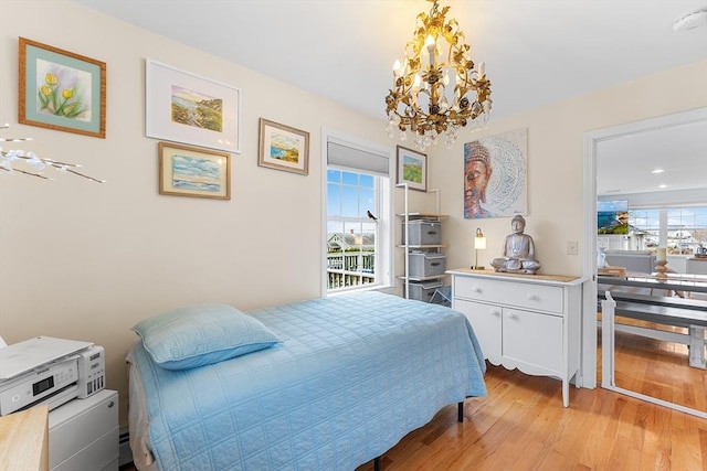 bedroom featuring light wood-type flooring and an inviting chandelier