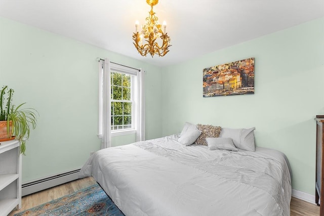 bedroom featuring hardwood / wood-style flooring, an inviting chandelier, and a baseboard radiator