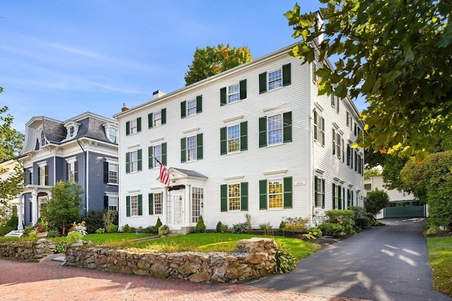 view of front of house with a chimney and a front yard