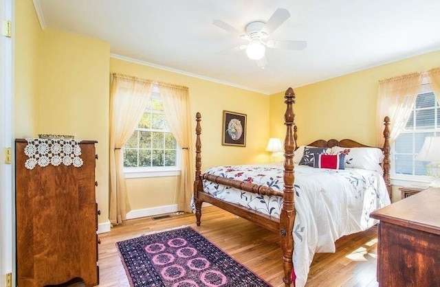 bedroom with ceiling fan, light wood-type flooring, baseboards, and ornamental molding
