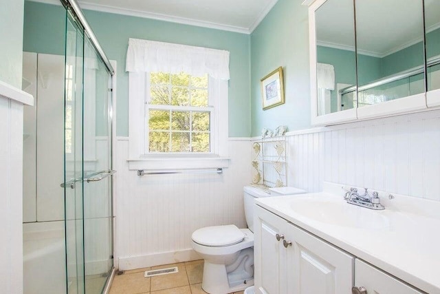full bathroom with toilet, a wainscoted wall, vanity, crown molding, and a shower stall