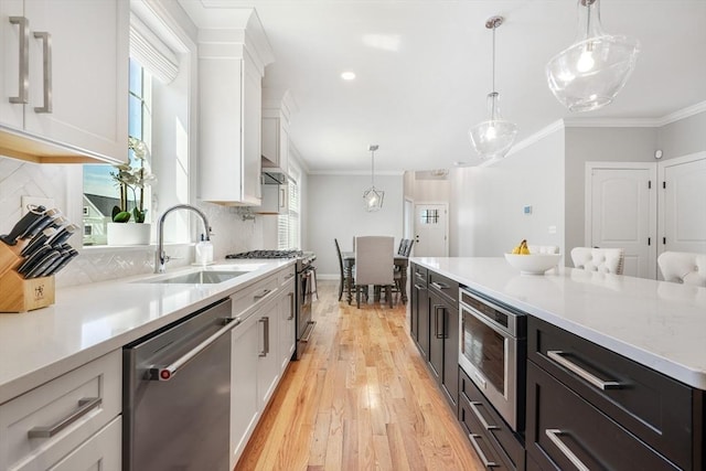 57 Sophia Dr, Rehoboth, MA 02769 - kitchen featuring a sink, decorative backsplash, stainless steel appliances, white cabinets, and light wood-type flooring