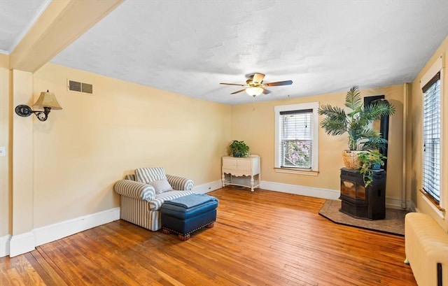 112 Lawrence St, Fitchburg, MA 01420 - sitting room with radiator heating unit, hardwood / wood-style flooring, baseboards, ceiling fan, and a wood stove