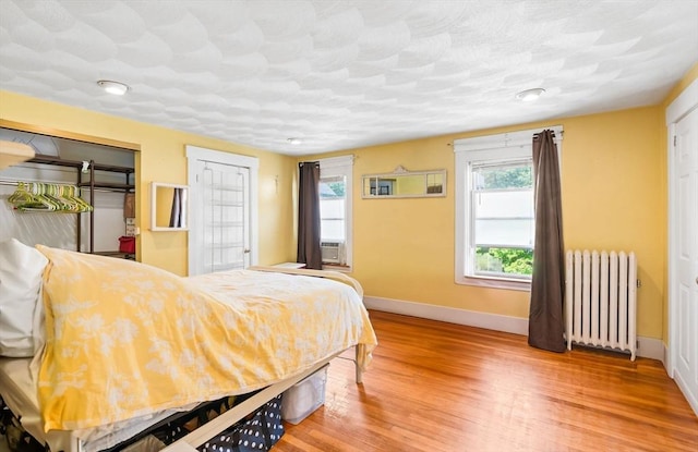 112 Lawrence St, Fitchburg, MA 01420 - bedroom featuring radiator, baseboards, wood finished floors, and a closet