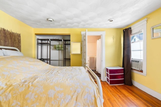 112 Lawrence St, Fitchburg, MA 01420 - bedroom featuring radiator heating unit, wood finished floors, baseboards, a closet, and cooling unit
