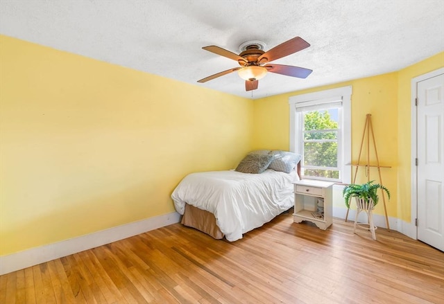 112 Lawrence St, Fitchburg, MA 01420 - bedroom with baseboards, hardwood / wood-style flooring, a ceiling fan, and a textured ceiling