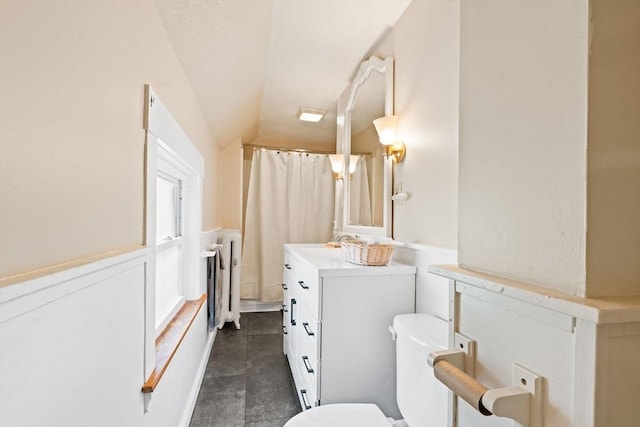 112 Lawrence St, Fitchburg, MA 01420 - full bathroom featuring lofted ceiling, toilet, vanity, wainscoting, and curtained shower
