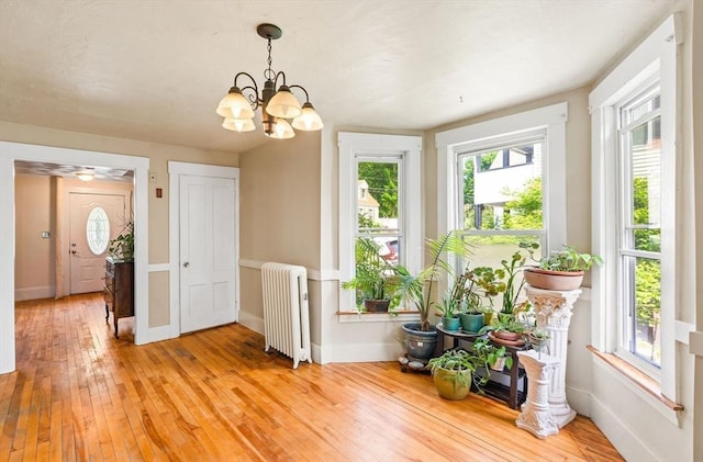 112 Lawrence St, Fitchburg, MA 01420 - dining space featuring radiator heating unit, light wood-style flooring, a chandelier, and baseboards
